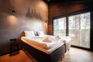 a bedroom with a large bed in front of a window at Cottage Finland- Levin Hehku B in Levi