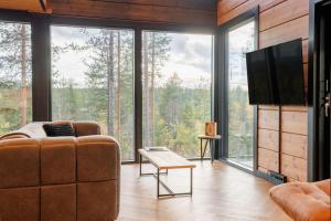a living room with a couch and a large window at Cottage Finland- Levin Hehku B in Levi