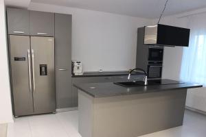 a kitchen with a stainless steel refrigerator and a counter at House in Brasov in Săcele