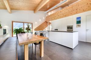 a kitchen with white cabinets and a wooden table at Panorama Chalet Bellavista in Brand