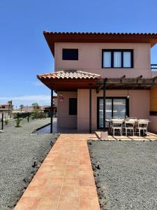 ein Haus mit einem Tisch und Stühlen davor in der Unterkunft Villa Majanicho con piscina in Lajares