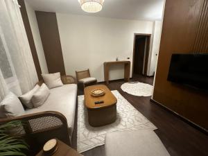 a living room with a couch and a flat screen tv at Hotel Apartment New Cairo in Cairo