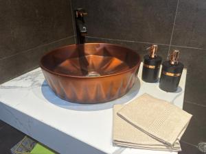 a copper bowl on a counter with two perfume bottles at Hotel Apartment New Cairo in Cairo +41 photos