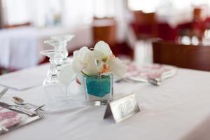 stół z białą tkaniną i wazą z kwiatami w obiekcie Hotel Singapore w mieście Milano Marittima