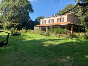 a large house in a yard with a grass field at Chambre d'hôtes Sous Les Grands Chênes ZEN in Saint-Étienne-de-Corcoué