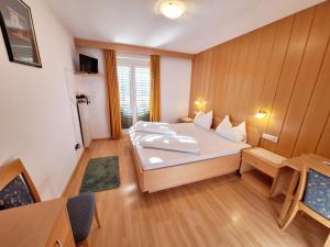 a bedroom with a large white bed in a room at Hotel Pörnbacher in Valdaora
