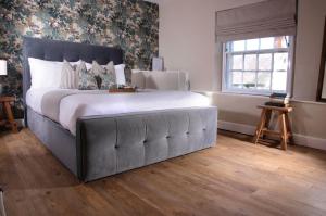 a bedroom with a large bed with a large headboard at The George & Dragon in Belper