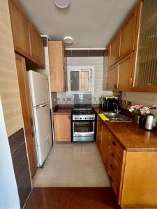 a kitchen with wooden cabinets and a white refrigerator at عيون مصر للشقق الفندقيه in Cairo