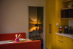 a room with a kitchen and a bedroom with a bed at la maison des Poteries in Chanteloup-les-Bois