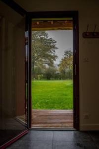 an open door with a view of a field of grass at la maison des Poteries in Chanteloup-les-Bois