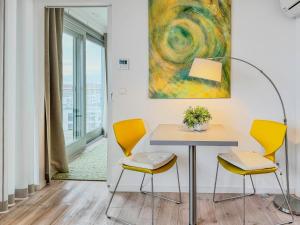 a table and chairs in a room with a painting at Speicherresidenz App 6 1 -Wasserblick in Barth