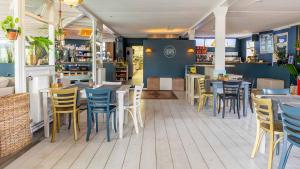 a restaurant with blue and yellow chairs and tables at Molecaten Park Wijde Blick in Renesse +21 photos