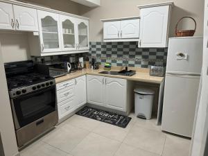 uma cozinha com armários brancos, um lavatório e um frigorífico em Deluxe Modern 1BR I Pool with Amazing Sea Views I Ideal Location em Gros Islet