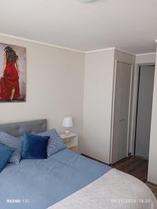 a bedroom with a bed and a painting on the wall at Disfruta de Valparaiso in Valparaíso