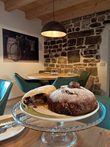 una torta su un piatto di vetro su un tavolo di Corte Varola B&B Zia Marisa a Belluno
