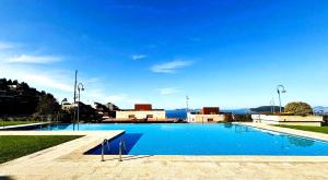 a large swimming pool with the ocean in the background at Holibai, Arco Da Vella, Dúplex de lujo in Baiona