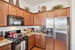 a kitchen with wooden cabinets and a stainless steel refrigerator at Cozy Granville Retreat with Modern Amenities, nearby Scenic Trails & Pristine Lakes of Prescott home in Prescott Valley