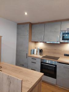 a kitchen with stainless steel appliances and wooden cabinets at Ferienwohnung Tramunt im Hotel Casada in Galtür
