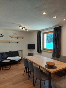 a living room with a table and a bedroom at Ferienwohnung Tramunt im Hotel Casada in Galtür