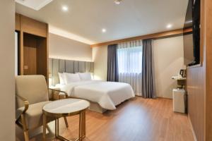 釜山Deokcheon Den Basta Hotel的配有床、桌椅的酒店房间