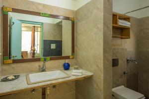 une salle de bain avec un lavabo et un miroir et des toilettes dans l'établissement Hollyhock Cottage by VEO - Part of StayVista, à Rāmgarh 22 autres photos