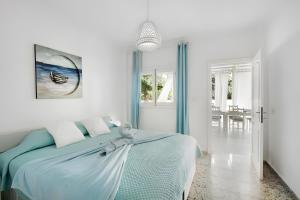 ein weißes Schlafzimmer mit einem Bett mit einer blauen Decke in der Unterkunft Biofinca Mi Sol in Adeje