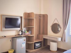 a room with a television and a small refrigerator at Gia An Hung Guest House in Mui Ne