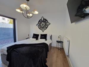 ein Schlafzimmer mit einem Bett und einer Uhr an der Wand in der Unterkunft Modern & Spacious 5 Bedroom Bungalow with Parking Near Brecon Beacons & Bike Park Wales in Cefn-coed-y-cymmer