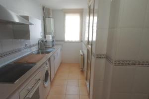 una cucina bianca con lavandino e finestra di Apartamento con 3 dormitorios y plaza de garaje a Tudela de Duero