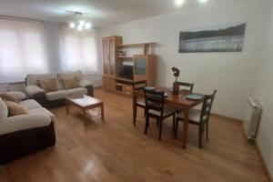 un soggiorno con un divano, un tavolo e delle sedie di Apartamento con 3 dormitorios y plaza de garaje a Tudela de Duero