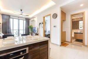 a kitchen and living room with a table and a clock at SeaView R&F 4pax-1BR 10mis to CIQ JBSentral CitySquare in Johor Bahru +7 photos