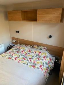 莱马特Mobil home climatisé 6,8 Pers SIBLU BONNE ANSE PLAGE LA PAMYRE LES MATHES的一间卧室,床上放着鲜花 更多25张照片