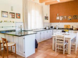 a kitchen with a large island with a table and chairs at Nuffara - a charming traditional Farmhouse with a large pool in Xagħra