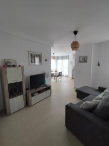 a living room with a couch and a flat screen tv at Casa Al Castello in Cómpeta