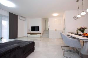 a living room with a couch and a table and a television at Villa Stella - CROWONDER LUXURY RENT in Turanj