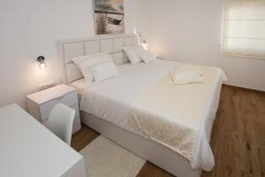 a white bedroom with a large white bed with white pillows at Villa Stella - CROWONDER LUXURY RENT in Turanj +43 photos