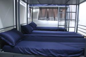two bunk beds on a boat with blue sheets at Fostel- The Fort Hostel in Mumbai