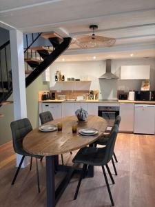 a dining room table and chairs in a kitchen at Châteaux de la Loire - Près de Tours - Cottage EAU CALME en Bord de Lac in Saint-Avertin