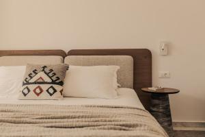 a bedroom with a bed with a pillow and a table at Saint George Hotel in Chrissi Akti