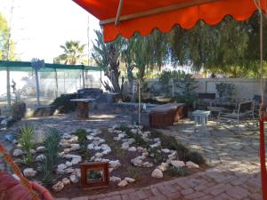 a patio with a garden with rocks and a table at Karoo Pomp in Vosburg
