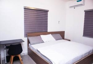 SangotedoMinimalist Haven King Bed 247 Power Security的一间卧室，配有一张床、一张桌子和一把椅子