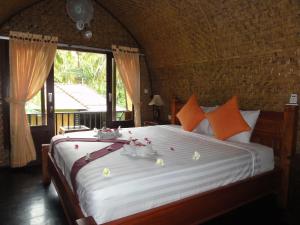 a bedroom with a large bed with flowers on it at Villas Ganjor in Gili Meno