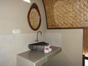 a bathroom with a stone sink and a mirror at Villas Ganjor in Gili Meno