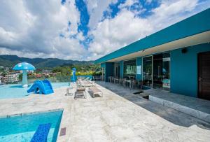 un edificio azul con piscina y parque infantil en Deluxe Twin Bed Apartment by Renttini, en Kamala Beach