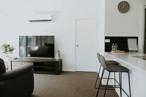 a living room with a couch and a tv at Spacious Stay On Shamrock, Bendigo in Golden Square +21 photos