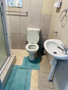 a bathroom with a toilet and a sink at Safaya Inn in Kempton Park +42 photos
