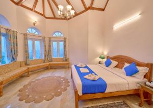 Un dormitorio con una cama grande con sábanas azules. en Emerald Stays Ooty By VOYE HOMES - Italian Luxury near Ooty Emerald Lake, en Ooty
