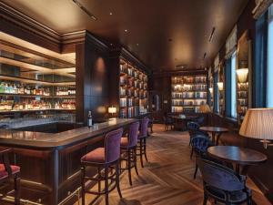 a bar in a restaurant with tables and chairs at HOTEL de L'ALPAGE in Chino