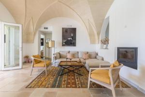 una sala de estar con un sofá y sillas en Terrazze Ai Demani by Perle di Puglia, en San Pietro in Bevagna
