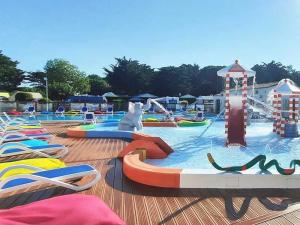 un parque acuático con una piscina con un perro en el agua en Camping 4 étoiles - Parc aquatique - eeibci, en Le Bois-Plage-en-Ré